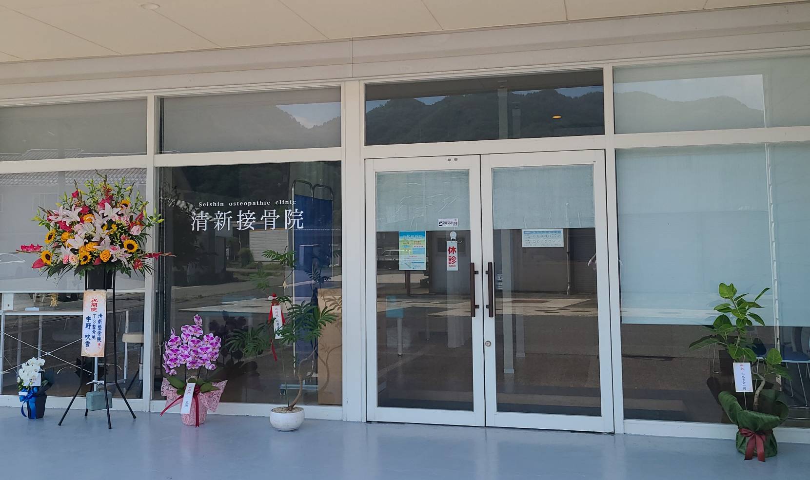 花を飾った接骨院の外観の写真